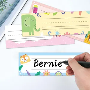 Detail view of colorful cartoon animal student desk name plates being written on by hand