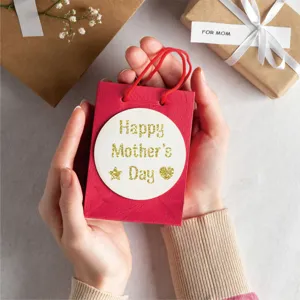Close-up of gold glitter alphabet stickers spelling Happy Mother's Day on a red gift bag
