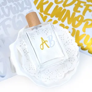 Detail of gold and silver alphabet stickers applied to a glass perfume bottle