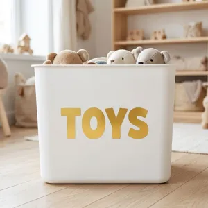 Gros plan d'autocollants alphabétiques dorés de 2,5 pouces sur un bac à jouets.