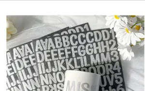 Close-up of 1-inch silver glitter alphabet stickers applied to a white ceramic mug detail