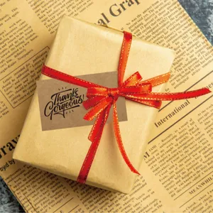 Close-up of vintage kraft paper gift tag with 'Thanks Gorgeous' text on a wrapped gift