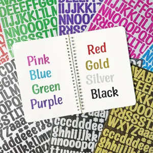 Close-up detail of colorful 1-inch glitter alphabet stickers shown on a white notebook