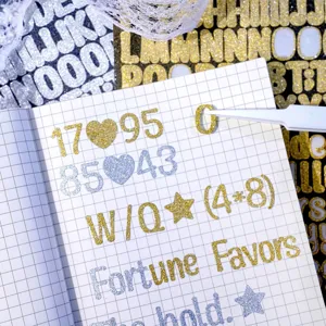 Macro view of gold and silver glitter letter stickers for journaling on grid paper