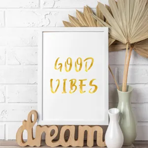 Macro view of shiny golden 'GOOD VIBES' alphabet stickers within a white frame