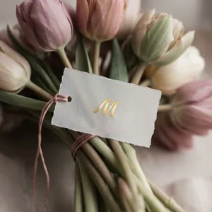 Close-up detail of a 0.5-inch gold foil alphabet sticker M on a translucent tag