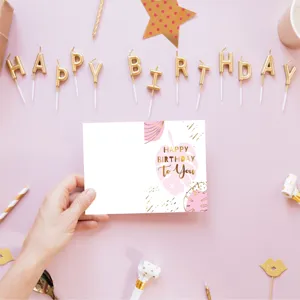 Pink birthday greeting card with gold foil lettering on a festive party background