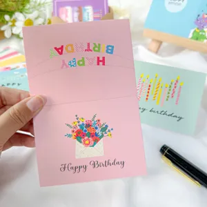 Gros plan sur carte d'anniversaire rose avec motif floral et texte Happy Birthday