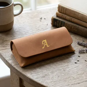 Détail d'un autocollant brillant lettre A dorée de 0,5 pouce sur une pochette en cuir