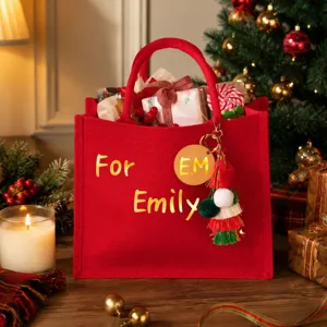 Detalle de pegatinas de letras doradas metálicas en una bolsa de regalo de Navidad de yute rojo