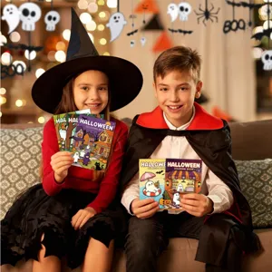 Bambini felici in costume di Halloween che tengono libri da colorare a tema in sala