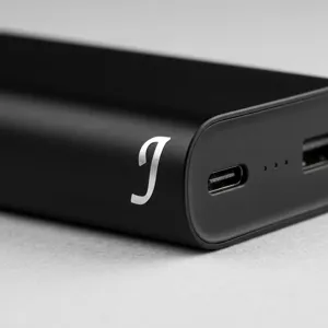 Détail macro d'un autocollant lettre J en métal argenté de 0,5 pouce sur un boîtier noir