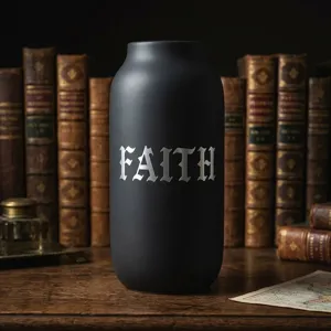 Silberner gotischer Buchstabenaufkleber 'FAITH' auf einer mattschwarzen Flasche