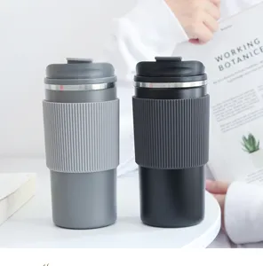 Due tazze da caffè isolate in acciaio inox con guaine antiscivolo in silicone sul tavolo