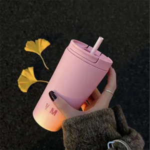 Hand hält einen rosa 12oz vakuumisolierten Kaffeebecher mit Strohhalm im Freien