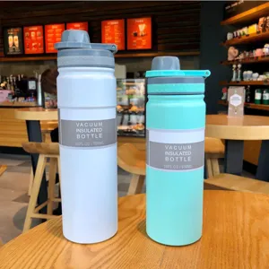 White and mint green vacuum insulated stainless steel water bottles in a cafe setting
