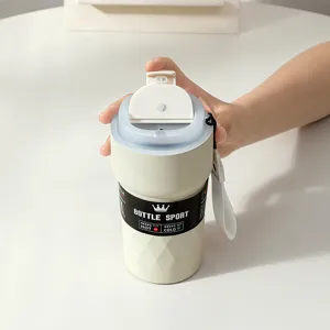 Detailed view of the functional flip-top lid and carry strap on a cream coffee mug
