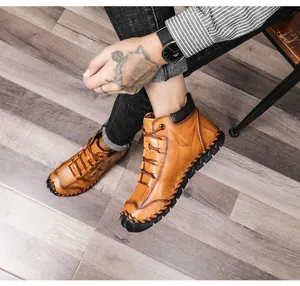 Close-up of vintage brown handmade leather men's boots on a light wooden floor background