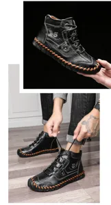 Detailed view of handmade black leather men's work boots with vibrant orange stitching