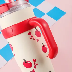 Vista ravvicinata del motivo a ciliegie rosse e del manico robusto su tazza crema 40oz