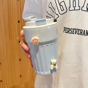 Nahaufnahme eines blau gestreiften Kaffeebechers mit süßem Bären- und Pfotendekor.