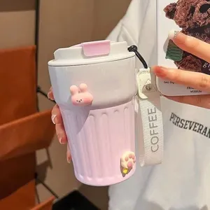 Nahaufnahme des rosa isolierten Kaffeebechers mit Streifen, 3D-Anhängern und Gurt