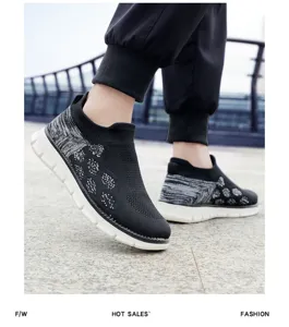 Vue détaillée de baskets en maille noire respirante portées aux pieds avec semelle blanche