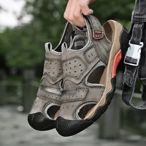 Close-up of men's leather outdoor sandals with breathable holes and protective toe cap.