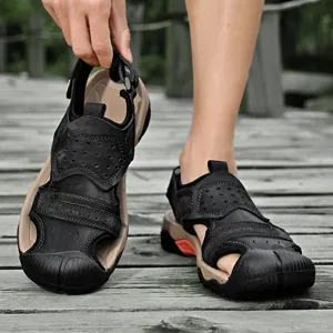 Macro view of black leather sandal detailing the protective toe cap and stitching