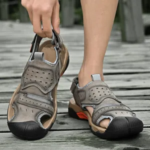 Detail of men's leather outdoor sandals featuring a breathable design on a wooden path.