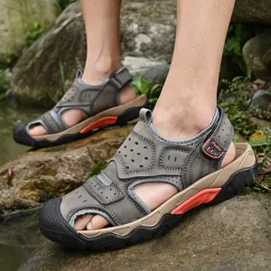 Close-up of men's durable outdoor leather sandals with protective closed-toe on rocks