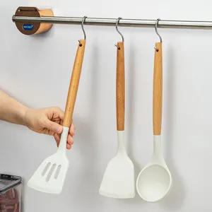 White silicone kitchen utensil set with wooden handles and hanging rack for cooking