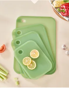Detailed close-up of a green plastic cutting board set decorated with fresh lemon slices