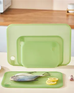 Macro view of green translucent plastic cutting board set featuring fish and lemon slices