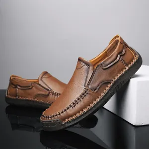 Primo piano di mocassini da uomo in pelle marrone con dettagli cuciti a mano e texture.