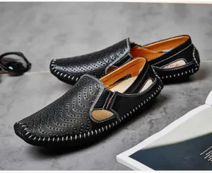 Primer plano de mocasines para hombre en cuero negro perforado con costuras a mano.
