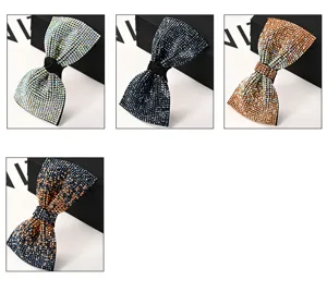 Close-up view of sparkling rhinestone bow hair clip, detailed crystal texture and spring design.