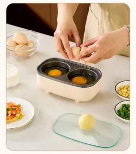 Macro view of cracking fresh eggs into a 2-hole non-stick electric breakfast cooker