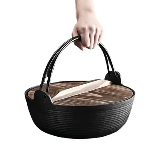 Traditionele Japanse gietijzeren sukiyaki pot met houten deksel en metalen greep