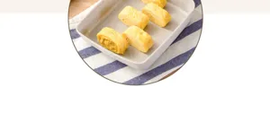 Detailansicht von fluffigen japanischen Tamagoyaki-Scheiben in einer Steinfanne