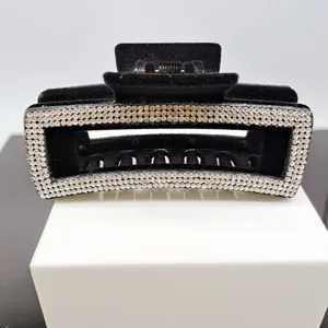 Vue rapprochée d'une pince à cheveux noire en strass avec des détails de cristaux brillants.