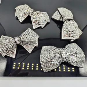 Vue détaillée de quatre pinces à cheveux nœud en strass argentés, accessoires brillants.