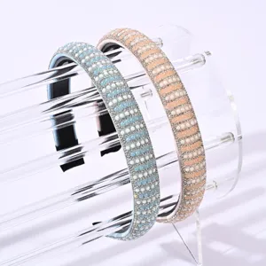 Primo piano dettagliato di fasce scintillanti decorate con strass e perle in blu e pesca.