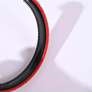 Primo piano dettagliato di un cerchietto rosso in strass con denti antiscivolo neri.