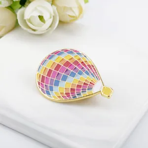 Macro detail view of a colorful enamel hot air balloon brooch with mosaic pattern