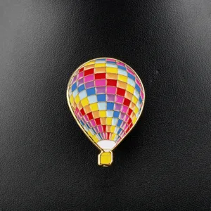 Detailed view of a colorful enamel hot air balloon brooch on black leather background