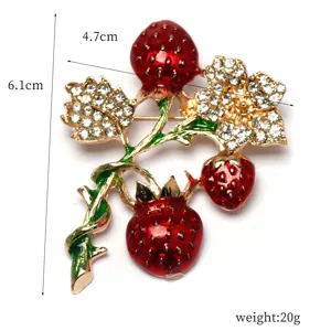 Detailed close-up of rhinestone strawberry and flower brooch pin, elegant design.