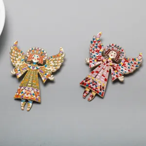 Close-up view of colorful mosaic enamel angel girl brooches showing exquisite wings and alloy details.