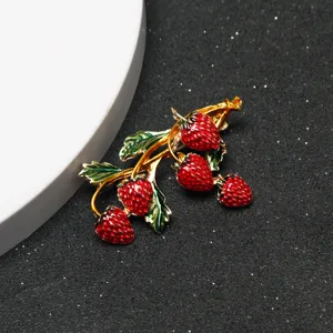 Detailed close-up view of the exquisite crystal strawberry brooch, showcasing fine enamel craft.