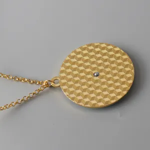 Gold alloy necklace pendant detail shot showing geometric pattern and spinning feature.
